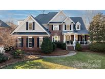 Two-story brick home with a large front yard and attached porch at 353 Killian Ct, Matthews, NC 28104