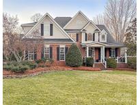 Two-story home with brick and siding exterior, landscaping, and a large yard at 353 Killian Ct, Matthews, NC 28104