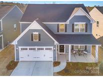Two-story gray house with white garage door, porch, and landscaping at 1844 Giana Ln, Monroe, NC 28112