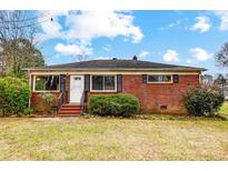 Brick ranch house with a front yard, steps, and landscaping at 2504 Juniper Dr, Charlotte, NC 28269