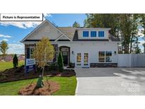 Two-story craftsman style home with stone accents and a landscaped lawn at 1014 Merganser Way, Indian Trail, NC 28079