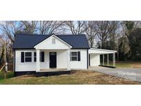 Charming white house with black roof and a covered carport at 502 North Dr, Cherryville, NC 28021