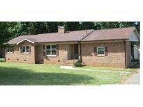 Brick ranch house with brown roof, nicely landscaped lawn at 1426 Reid Harkey Rd, Matthews, NC 28105