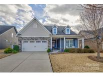 Two-story home with gray siding, stone accents, and a front porch at 517 Trillium Way, Belmont, NC 28012