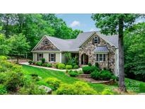 Charming home featuring stone accents, gray roof, tidy landscaping, and a lush green lawn at 6156 Falls Ridge Trl, Sherrills Ford, NC 28673