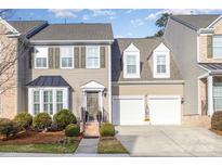 Two-story townhome with taupe siding, shutters, and a two-car garage at 14839 Rocky Top Dr, Huntersville, NC 28078