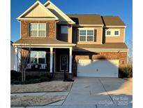 Two-story brick home with a large front porch and attached two-car garage at 1968 Sapphire Meadow Dr, Fort Mill, SC 29715