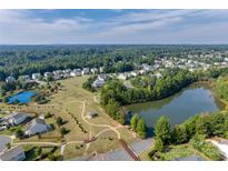 Aerial view of a community with houses, lake, tennis courts, and walking trails at 2229 Iron Works Dr # 21, Clover, SC 29710