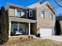 Two-story brick home with a welcoming front porch and attached garage at 2229 Iron Works Dr, Clover, SC 29710