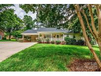 Charming single-story home featuring a welcoming front porch, carport, and lush green lawn at 3309 E Broad St, Statesville, NC 28625