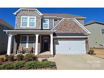 Two-story brick home with a front porch and two-car garage at 3001 Burton Point Ct, Waxhaw, NC 28173