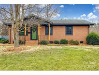 Charming brick home with a green front door and well-maintained lawn at 4328 Hancock Ter, Charlotte, NC 28205