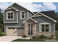 Two-story house with gray siding, stone accents, and a two-car garage at 9931 Cask Way, Huntersville, NC 28078