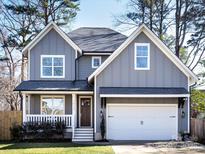 Charming two-story home with a gray exterior, white trim, and a well-maintained front yard at 1012 Rockway Dr, Charlotte, NC 28205