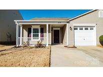 Tan house with a white garage door and a covered porch at 8705 Westhope St, Charlotte, NC 28216