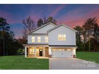 Two-story white house with a brick base, two-car garage, and landscaped lawn at 5240 Carden Dr, Charlotte, NC 28227