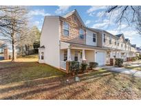 Tan and brown two-story townhome with a brick porch and landscaping at 5927 Pisgah Way, Charlotte, NC 28217