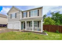 Charming two-story home boasts a welcoming front porch and a well-maintained lawn at 11677 Striker Ln, Midland, NC 28107
