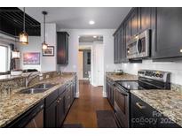 Modern kitchen featuring stainless steel appliances, granite countertops, and dark wood cabinetry at 2338 Yadkin Ave # 505, Charlotte, NC 28205