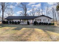 Brick ranch house with dark trim, landscaping, and a large yard at 605 Impala Dr, Albemarle, NC 28001