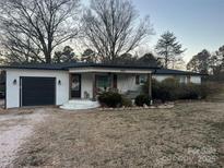 Charming ranch home with white brick exterior, covered porch, and attached garage at 3910 Centergrove Rd, Concord, NC 28025