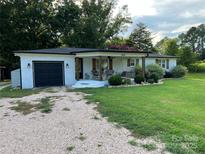 Charming ranch home with white brick exterior, covered porch, and a spacious front yard at 3910 Centergrove Rd, Concord, NC 28025