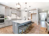 Modern kitchen with gray cabinets, quartz countertops, and an island at 9835 Quercus Ln, Huntersville, NC 28078
