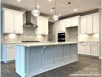 Modern kitchen with white cabinets, large island, and stainless steel appliances at 9831 Quercus Ln, Huntersville, NC 28078