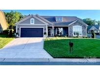 Charming single-story home boasts a dark garage, stone accents, and well-manicured lawn at 3100 Glacier Ct, Gastonia, NC 28056