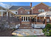 Brick home with spacious deck, stone patio, pergola, and steps leading to the yard at 5401 Sunningdale Dr, Charlotte, NC 28277