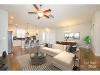 Open-concept living space featuring a modern kitchen, dining area, and a cozy seating arrangement at 7542 Waverly Walk Ave # 7542, Charlotte, NC 28277