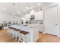 White kitchen with large island and stainless steel appliances at 1025 Lake Como Dr, Monroe, NC 28110