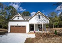 Charming two-story home with a welcoming front porch, lovely landscaping, and a two-car garage at 1037 Oakmont Dr, Rock Hill, SC 29732