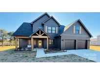 Two-story farmhouse with gray siding, two-car garage, and covered porch at 187 Lone Pine Rd, Statesville, NC 28625