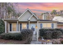 Tan house with shutters, front porch, and well-manicured landscaping at 9325 Four Mile Creek Rd, Charlotte, NC 28277