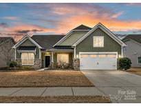 Two-story house with green siding, stone accents, and a two-car garage at 1410 Tranquility Blvd, Lancaster, SC 29720