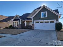 Two-story house with green siding, stone accents, and a two-car garage at 1410 Tranquility Blvd, Lancaster, SC 29720