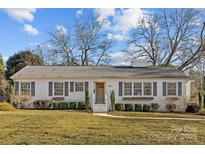 Charming ranch home with white brick exterior, gray shutters, and manicured lawn at 4526 Wedgewood Dr, Charlotte, NC 28210