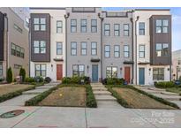 Modern townhouses with gray siding and red doors, landscaped yards at 539 W Tremont Ave, Charlotte, NC 28203