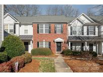 Brick front townhouse with a charming porch and well-manicured landscaping at 8044 Sapwood Ct, Matthews, NC 28104