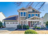 Two-story craftsman style home with a green exterior, two car garage, and landscaped yard at 12014 Grey Partridge Dr, Charlotte, NC 28278