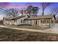 Charming one-story home with a large front yard and a convenient covered parking area at 6211 Rock Island Rd, Charlotte, NC 28278