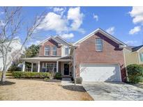 Brick two-story house with a two-car garage and landscaped yard at 7647 Black Hawk Ln, Tega Cay, SC 29708