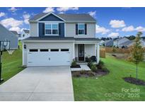 Two-story house with a two-car garage and landscaped lawn at 179 Tanner Loop, Troutman, NC 28166