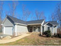 Gray house with stone accents, attached garage, and a covered porch at 34466 Lisa Dr, Albemarle, NC 28001