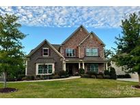 Two-story home with stone and shingle accents, welcoming porch, and landscaped lawn at 6022 Candlestick Ln, Lancaster, SC 29720