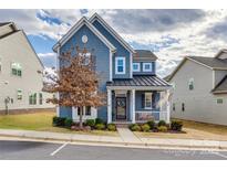 Two-story home with blue siding, metal roof, and front porch at 6142 Cloverdale Dr, Tega Cay, SC 29708