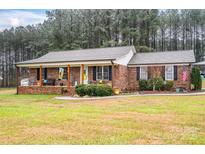 Brick ranch house with covered porch and landscaped yard at 6751 Lackey Rd, Vale, NC 28168