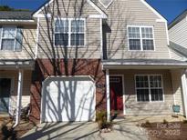 Charming townhouse with a one-car garage, red front door, and well-maintained landscaping at 8620 Robinson Forest Dr, Charlotte, NC 28277