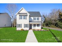 Two-story house with a gray door, white siding, and a landscaped lawn at 114 E 5Th Ave, Gastonia, NC 28052